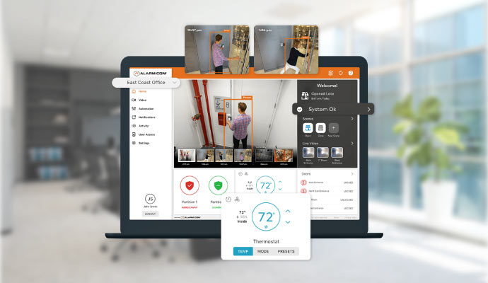 Laptop displaying Alarm.com dashboard with security camera