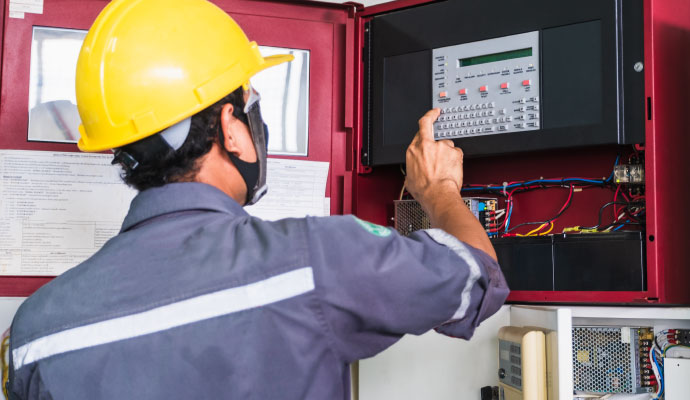 a person performing maintenance service in a fire alarm system