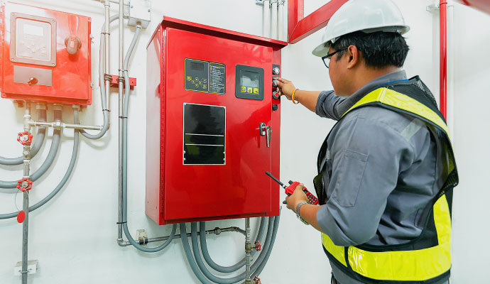 a person performing monitoring service in a wall mounted fire alarm system