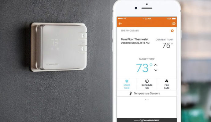 Smart thermostat on wall with mobile app