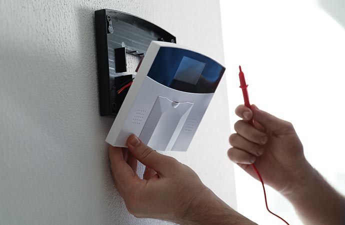 a person is installing intercom system against a wall