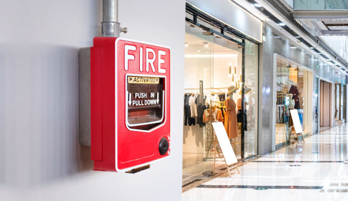 red fire alarm activation unit mounted on a white wall